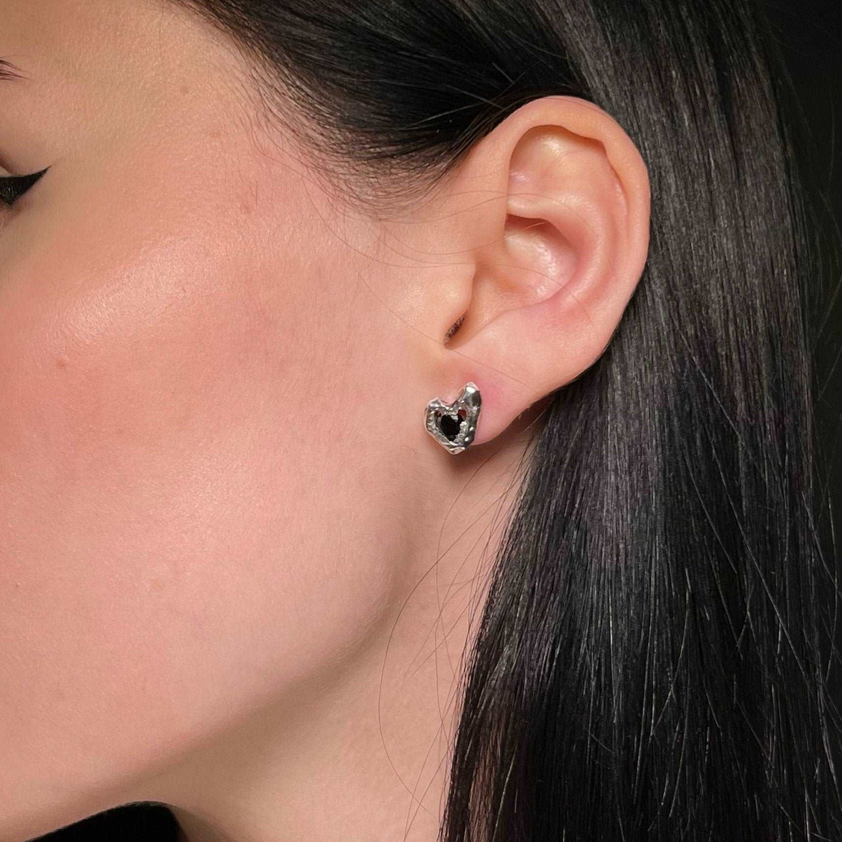 Pair of conch stud earrings with black zircon accents for a bold look.