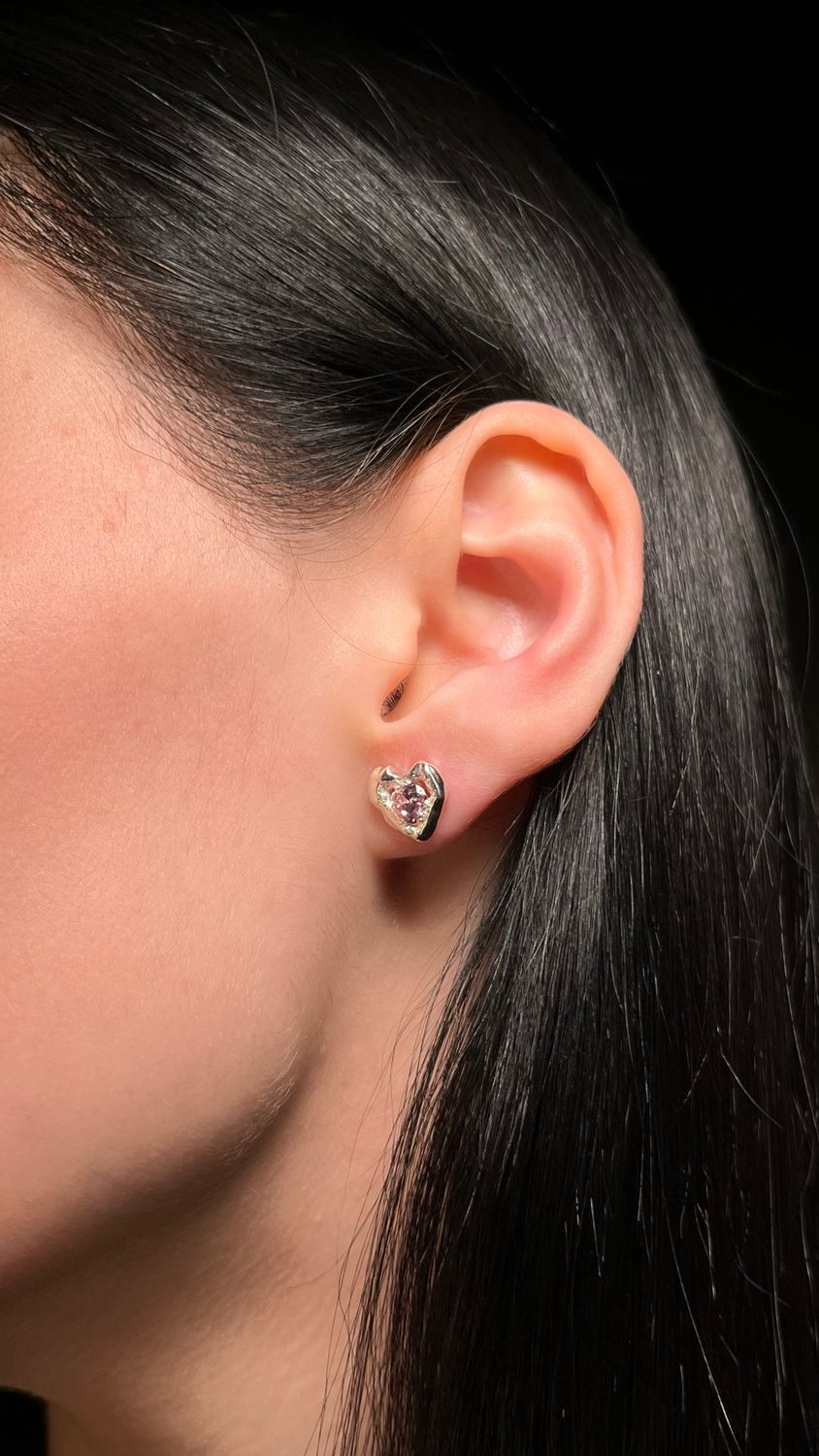 Elegant silver earrings featuring pink stones in a heart shape.