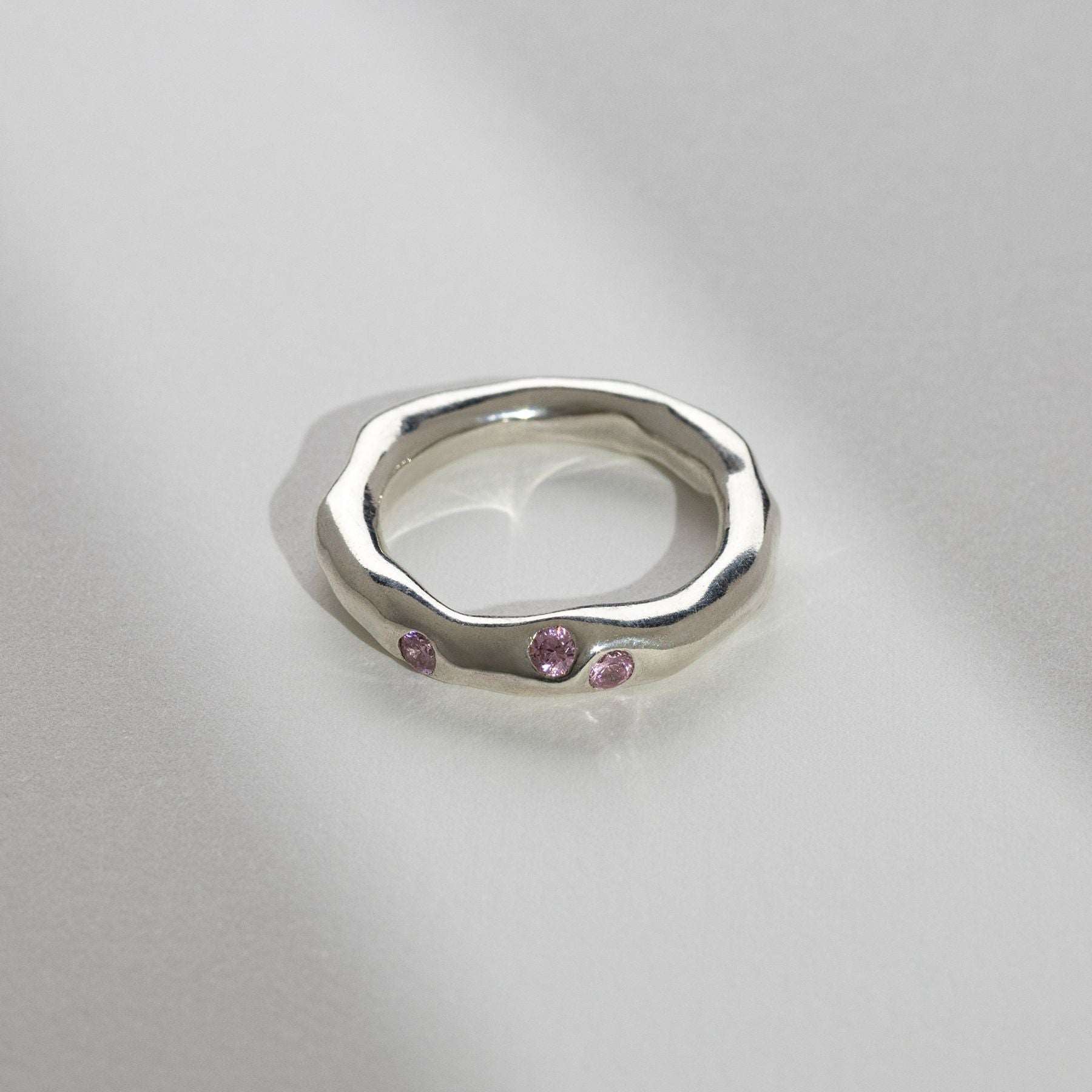 Beautifully handcrafted ring with a pink stone and a variety of textured details.