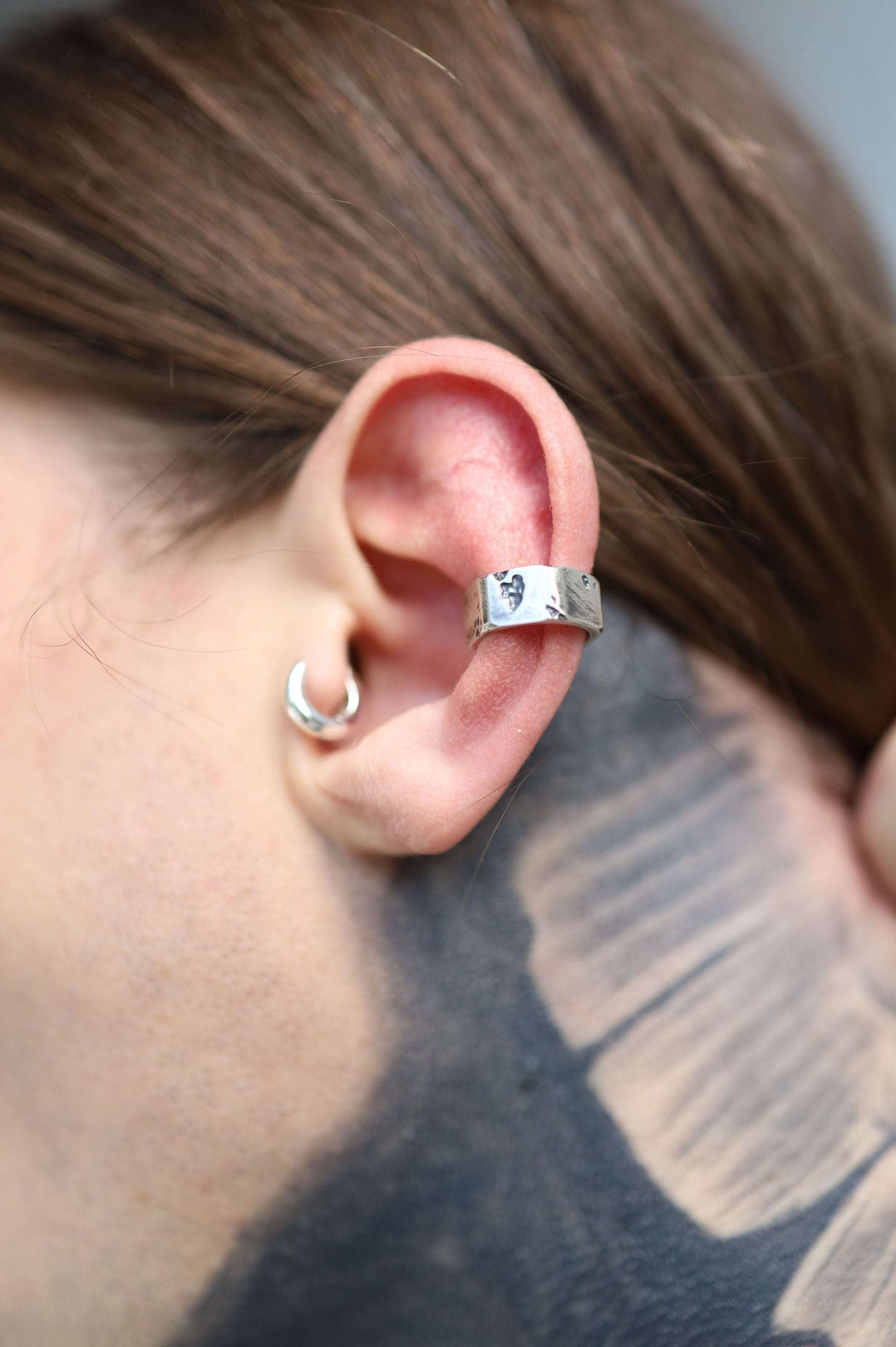 Avant-garde silver ear cuff blending mechanical precision with cutting-edge fashion accessories