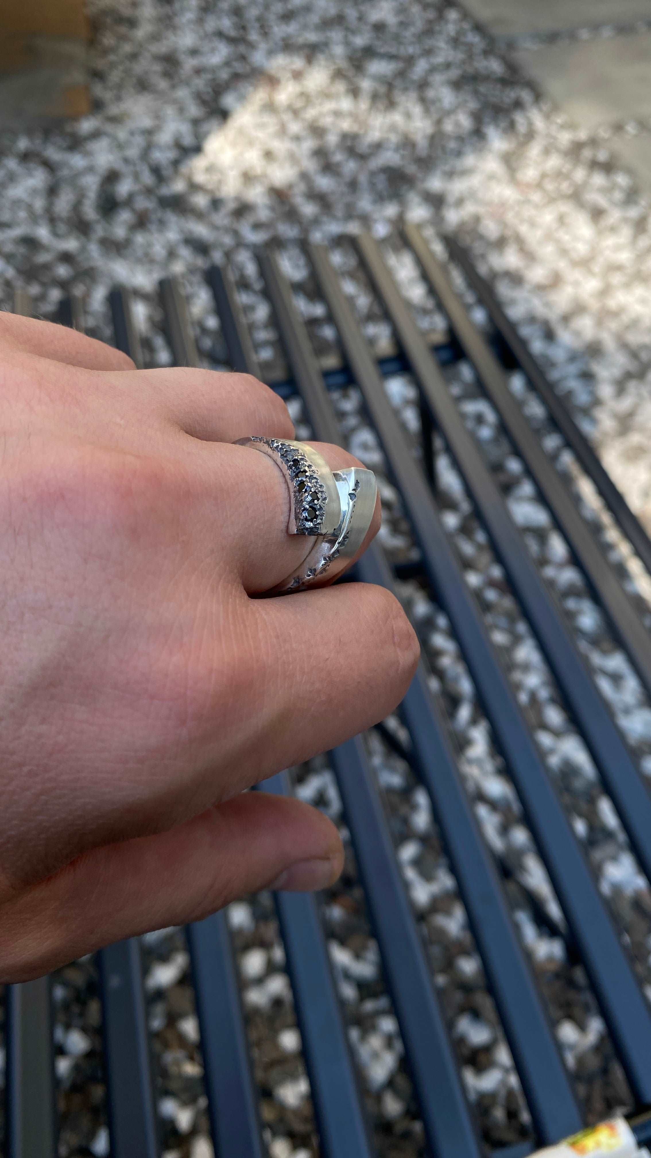 Hand showcasing a Dych.net sterling silver ring with a black spinel gem.