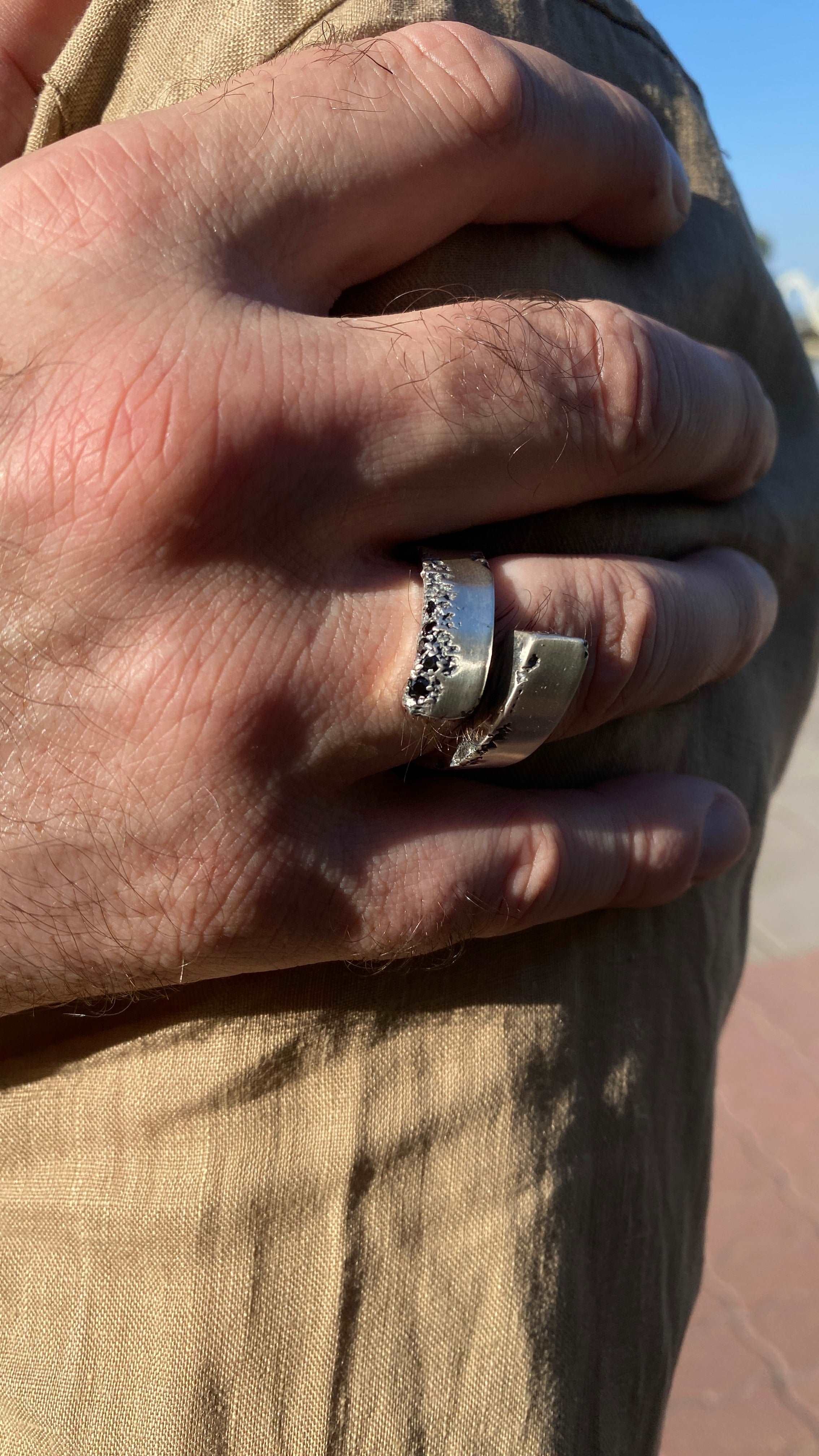 Modern open silver ring with a striking black spinel accent.