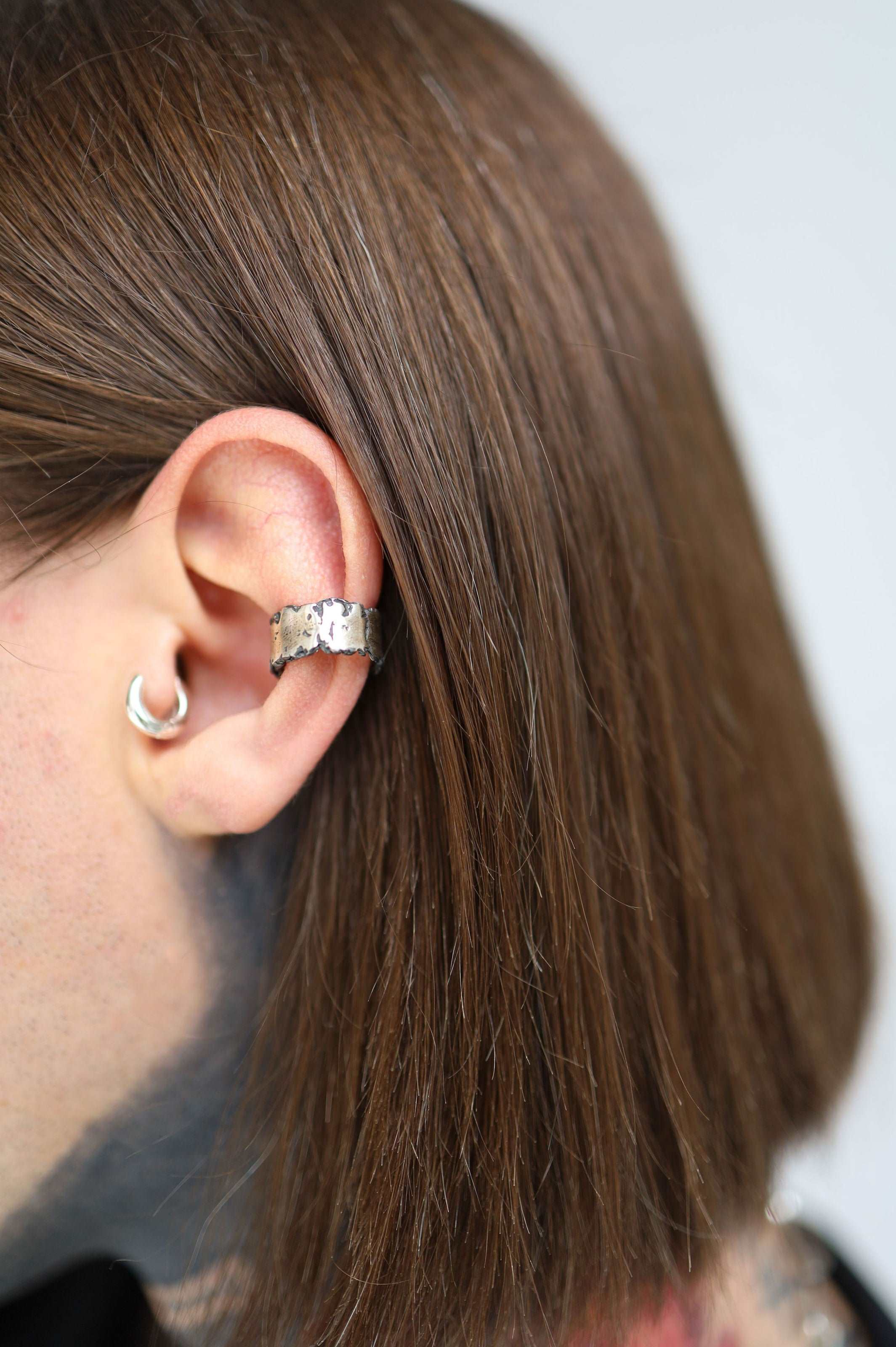 Elegant silver ear cuff creating dramatic visual impact for fashion-forward personal styling