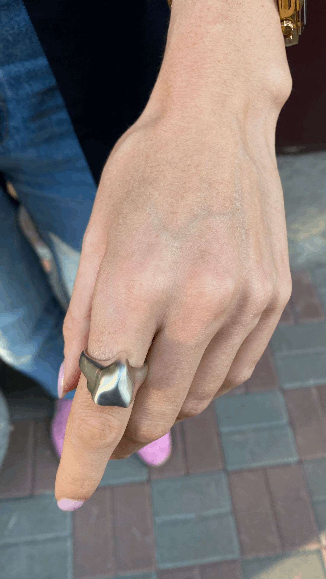 Close-up view of a chunky triangle ring in polished silver.