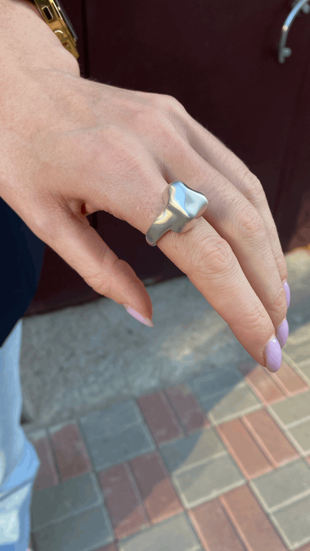 Geometric chunky triangle ring placed on a minimalist background.